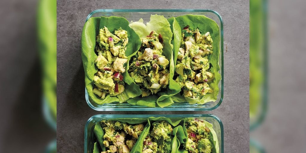 chicken avocado salad filled lettuce cups arranged inside glass meal prep containers