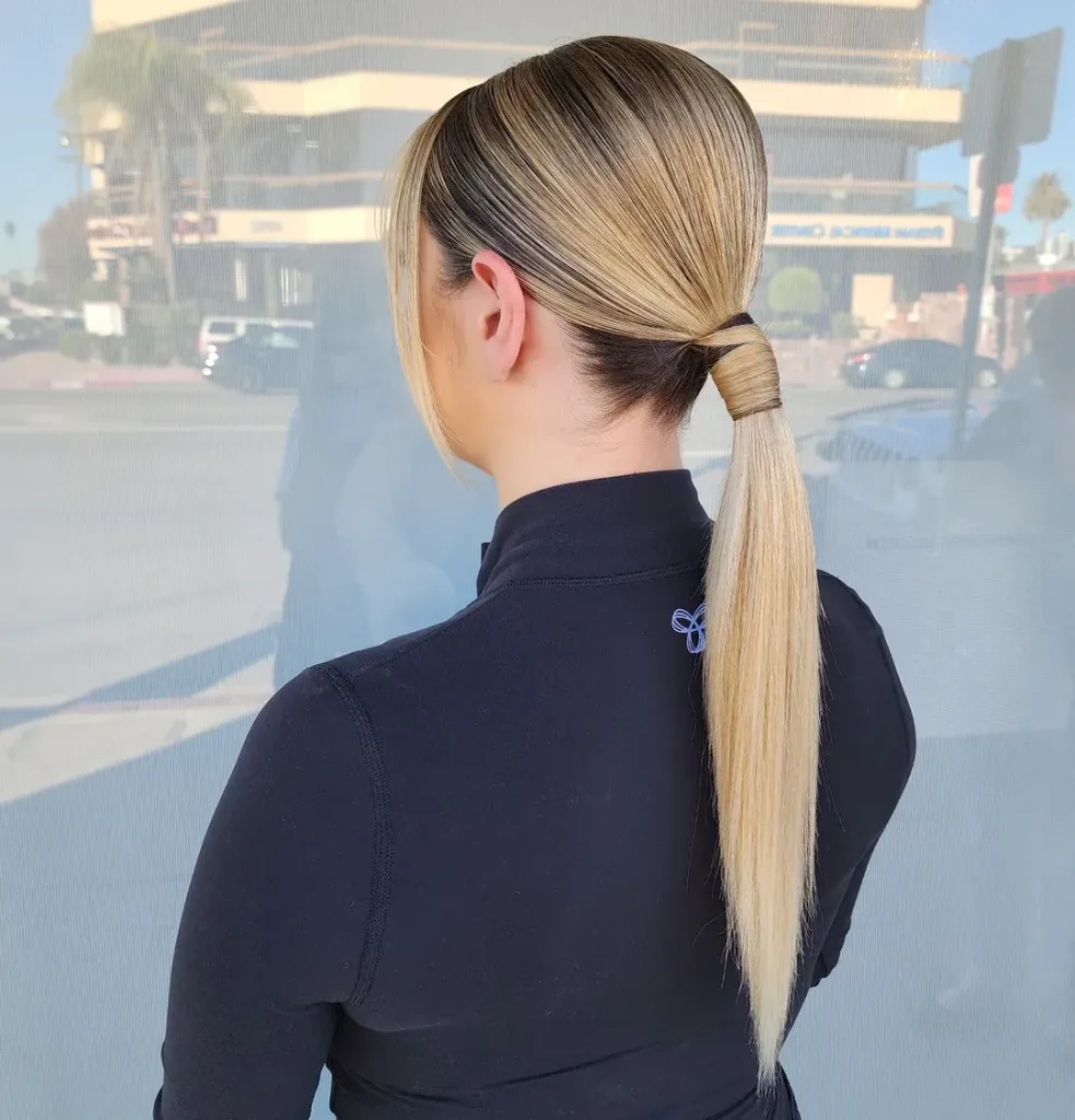 woman with sleek blonde wrapped ponytail hairstyle from the back view