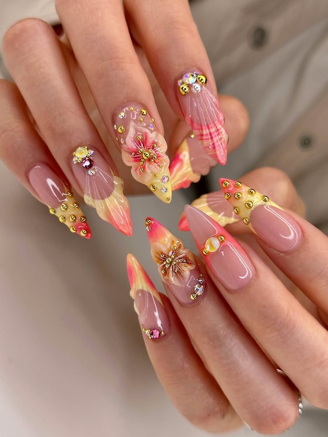 textured pink 3d seashell cat eye nails with gold beads and floral summer accents.