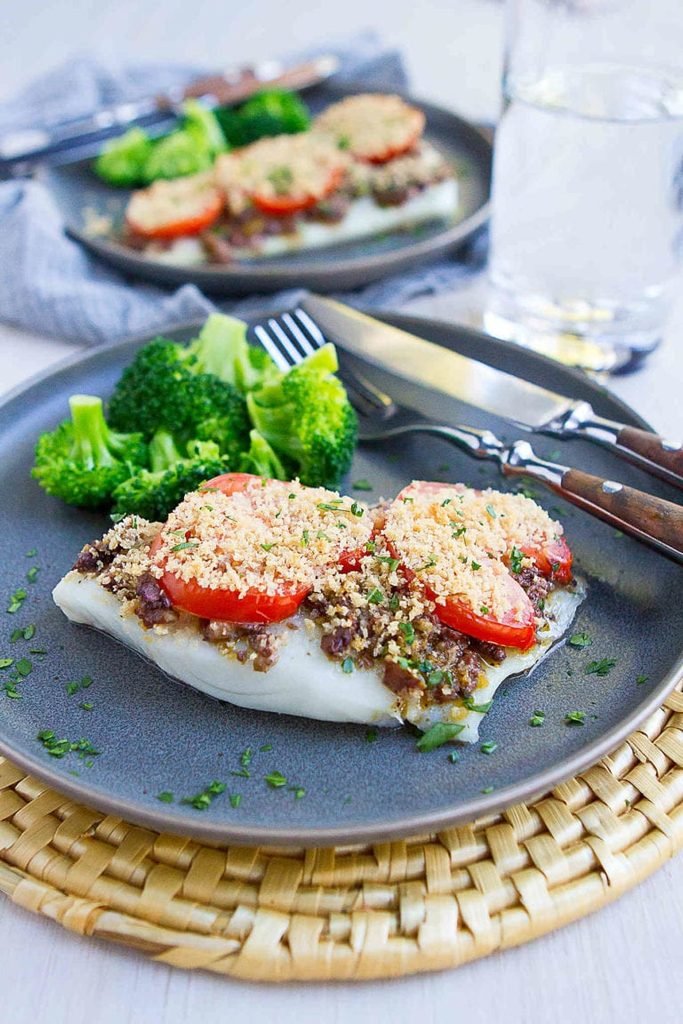 baked cod fillet topped with olive tapenade and sliced tomatoes served with steamed broccoli