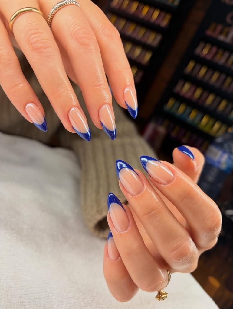 pointed almond nails with a classic deep blue French tip design
