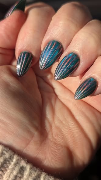 teal almond nails with orange and green multichromatic cat eye shell pattern