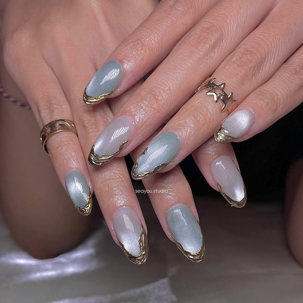 silver and sage green cat eye nails featuring metallic gold French tips