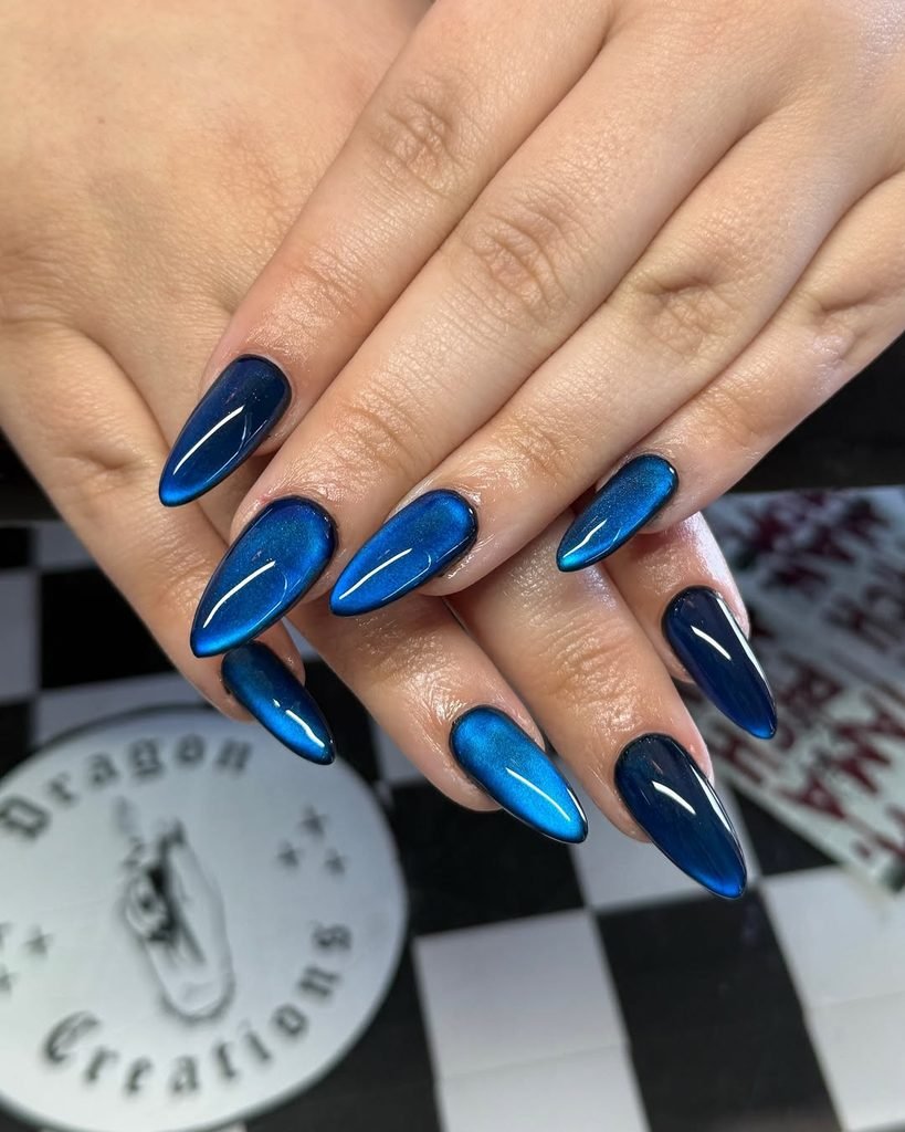 deep blue shimmer cat eye manicure on long almond nails