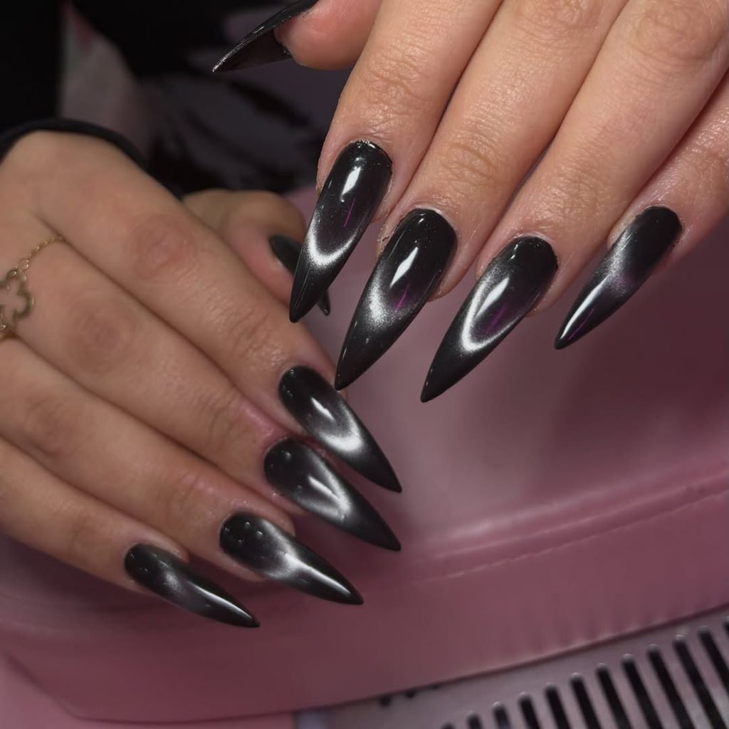long black stiletto nails with a reflective silver magnetic line design