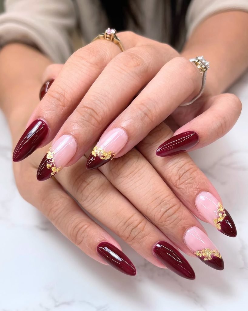 burgundy and nude almond nails accented with textured gold foil details