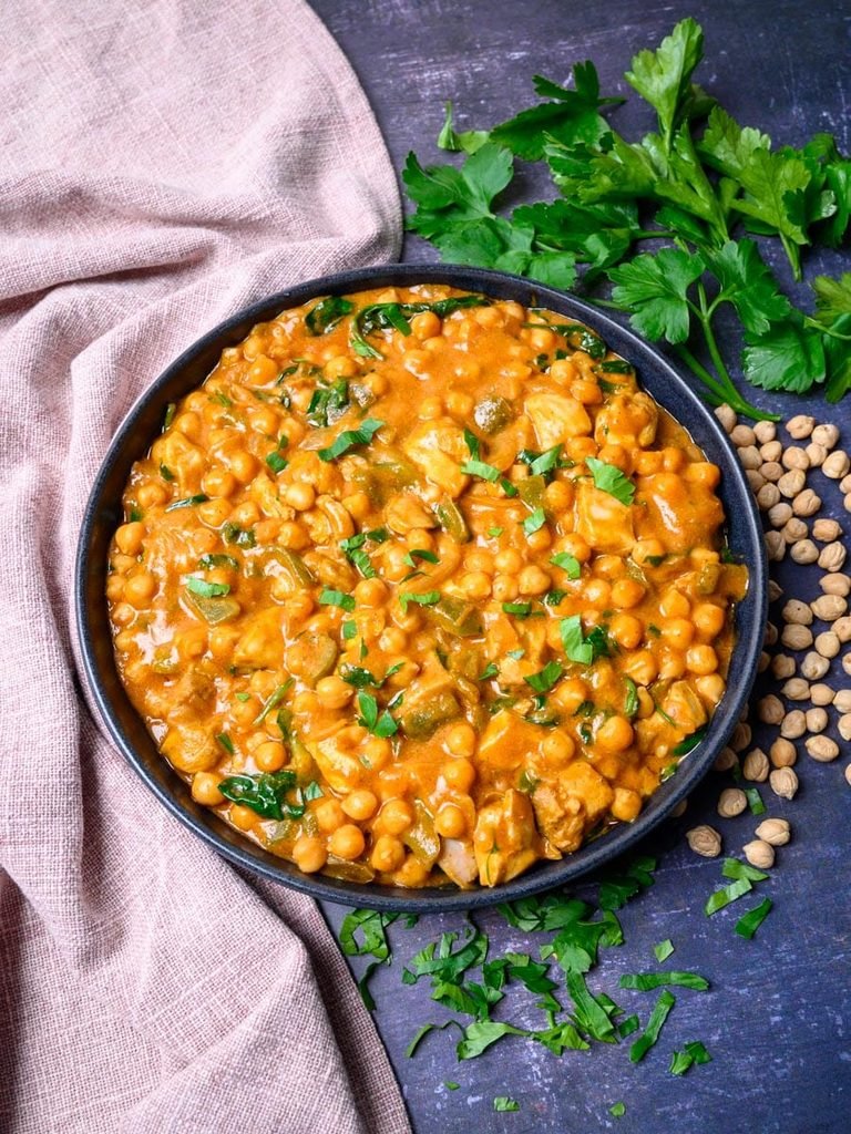 creamy chicken and chickpea curry topped with fresh parsley in a bowl