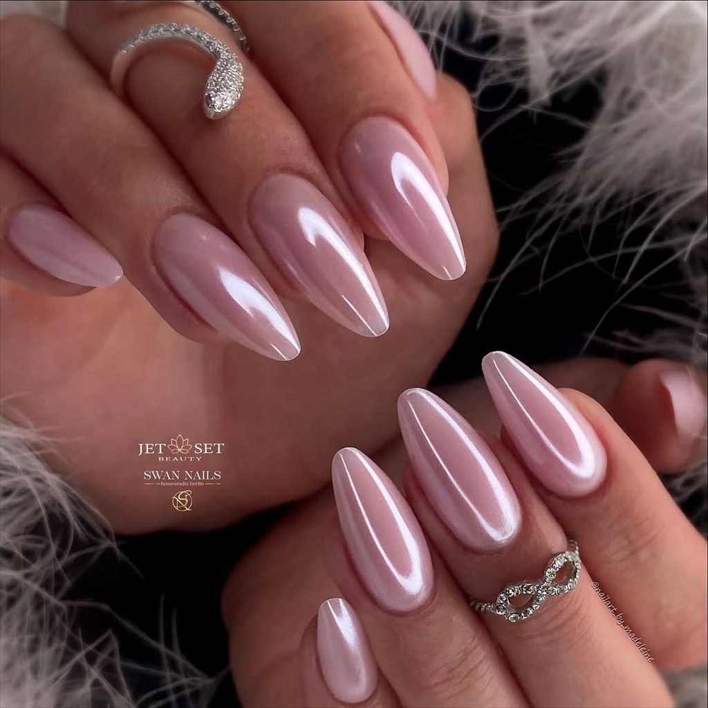 nude almond nails with a glossy iridescent pink pearl chrome finish