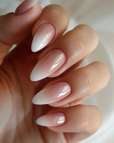 glossy almond nails with a subtle pink to white ombre chrome finish