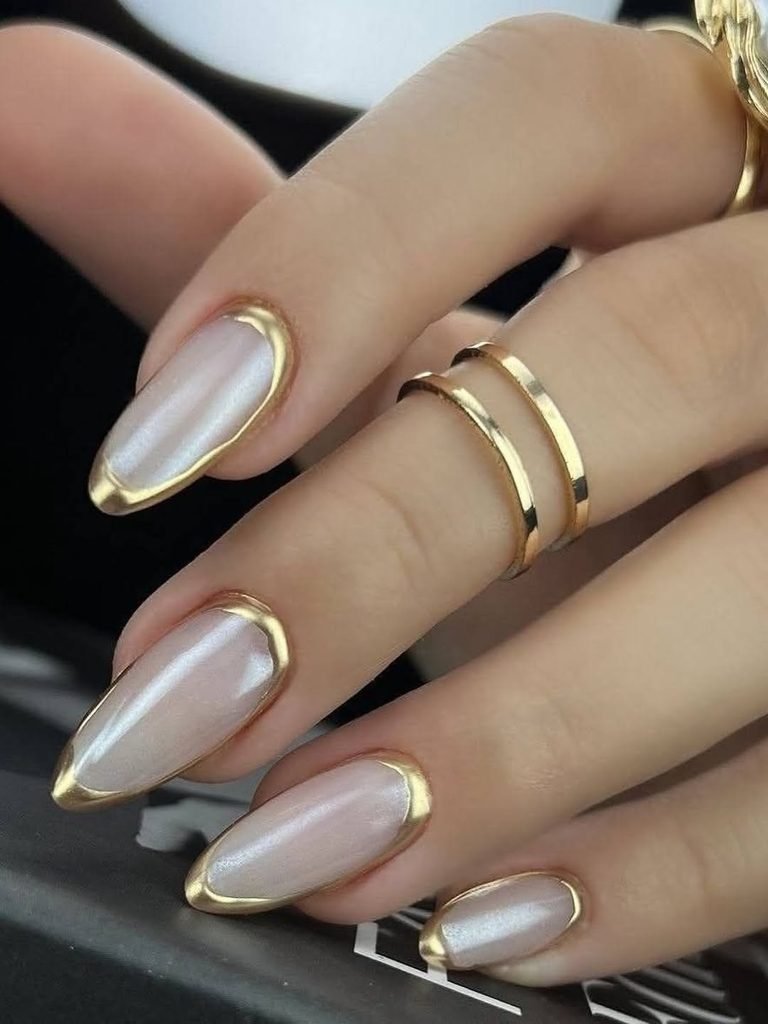 milky white almond nails with a raised metallic gold border outline