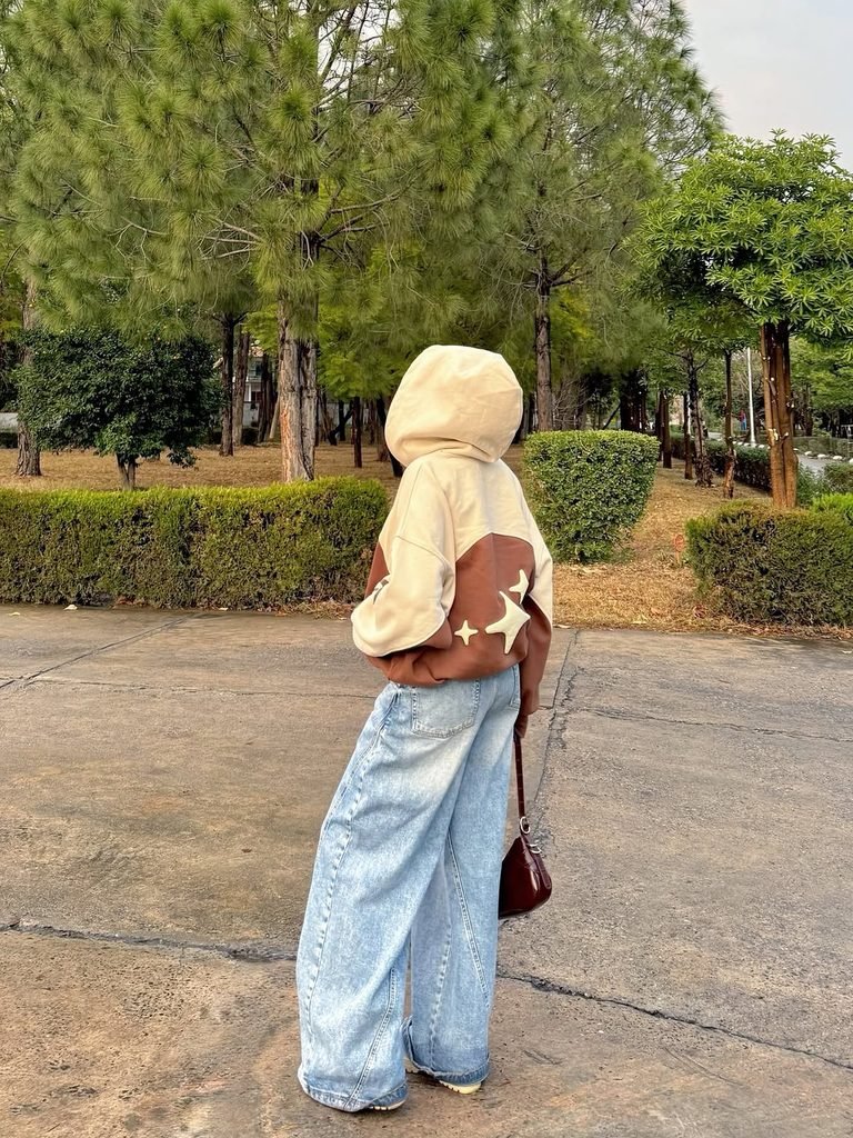 person from behind in oversized hoodie with stars and wide leg jeans