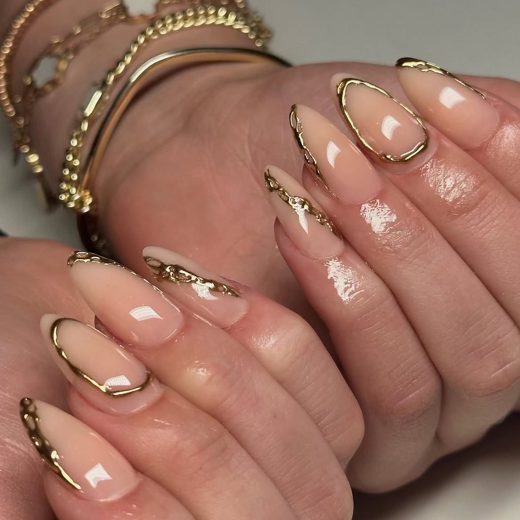glossy almond nude gel nails accented with metallic gold abstract foil trim