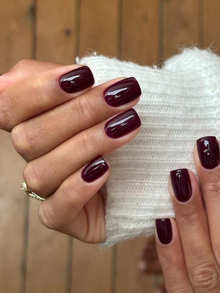 classic short square gel nails polished in a rich glossy deep burgundy color