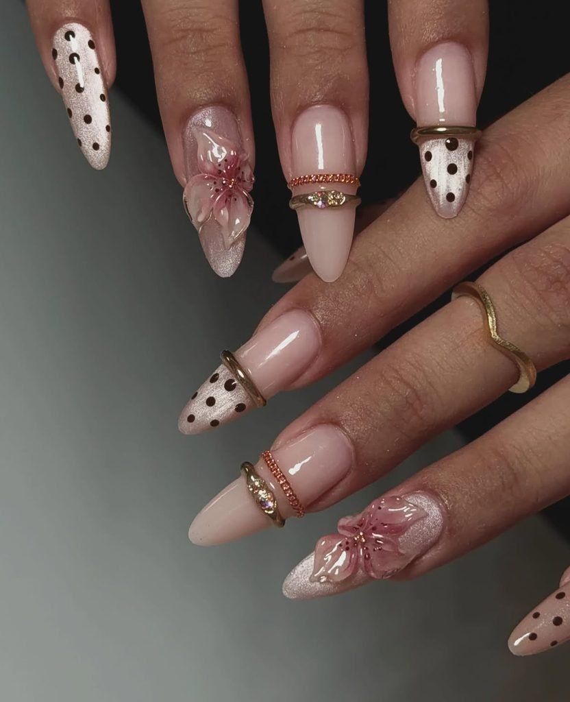 nude stiletto gel nails decorated with 3d pink flowers and black polka dots