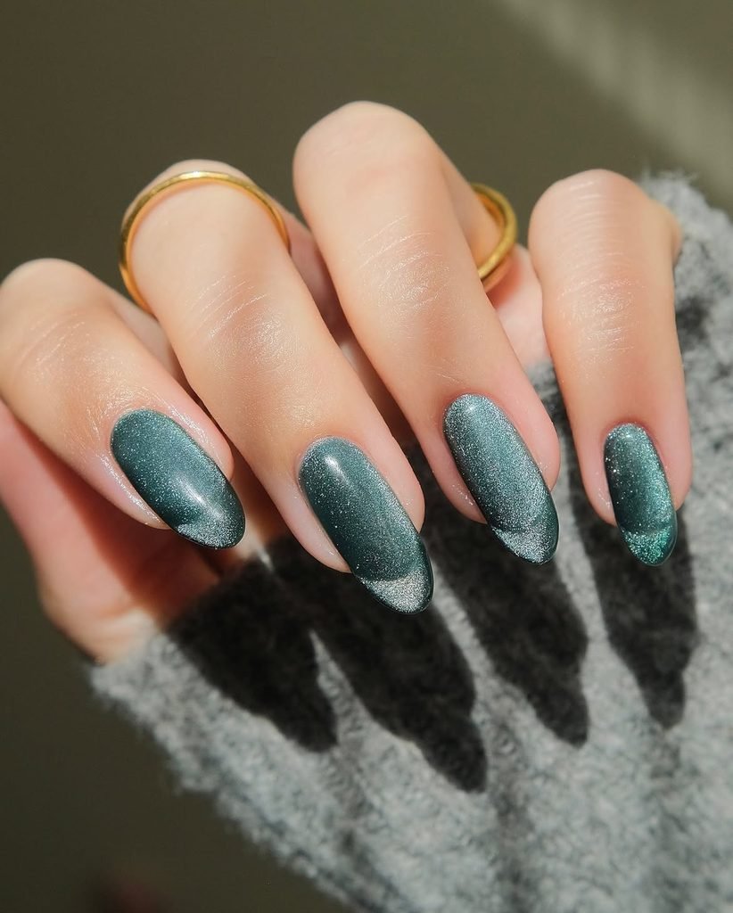 shimmering teal magnetic cat eye gel nails on long oval shaped fingers