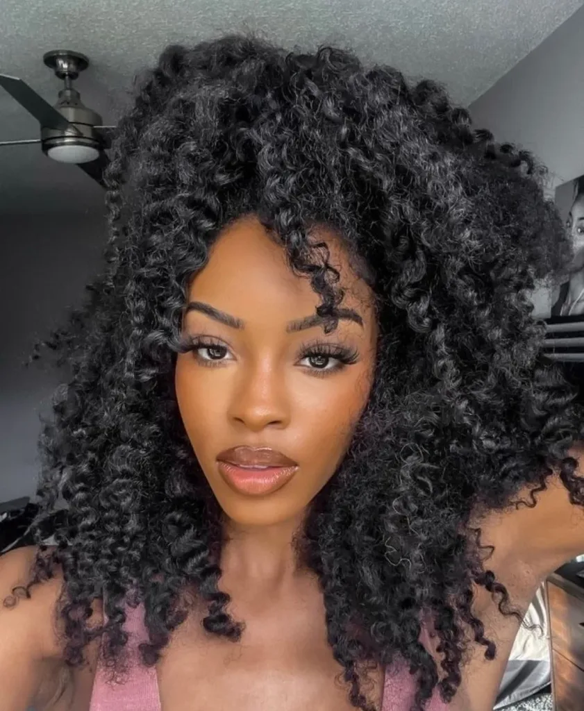 woman with voluminous, bouncy kinky curly black hair framing her face