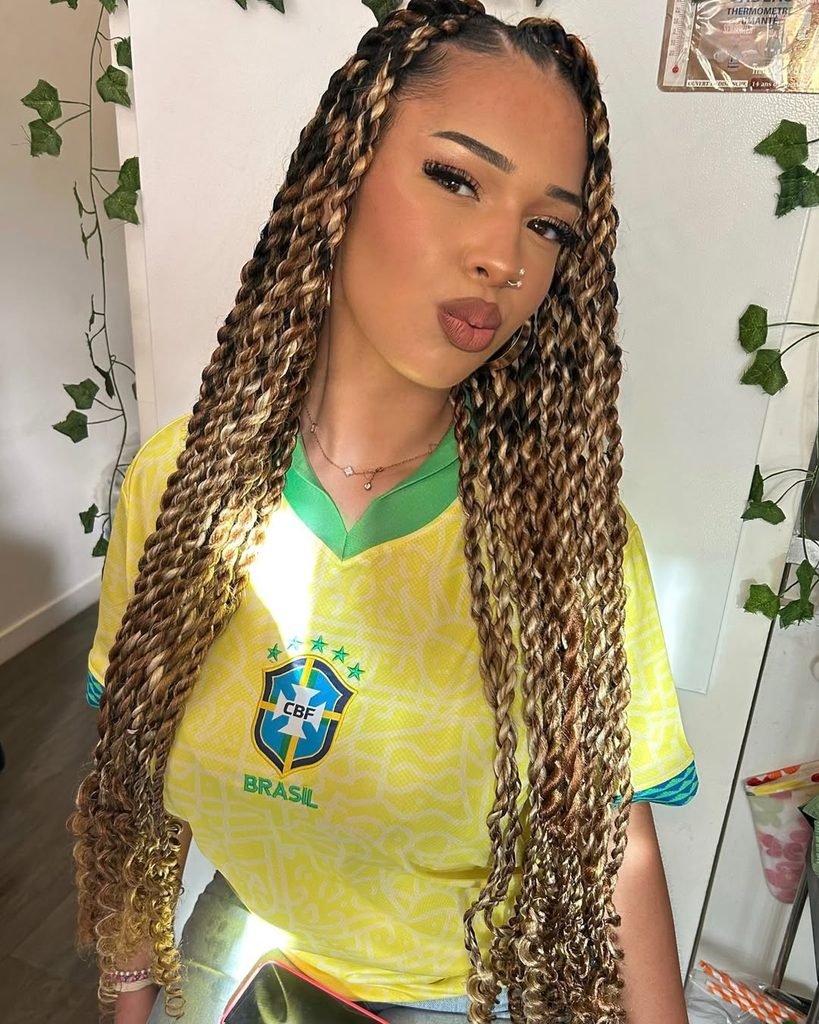 woman with long blonde and brown ombre twist braids wearing a yellow jersey