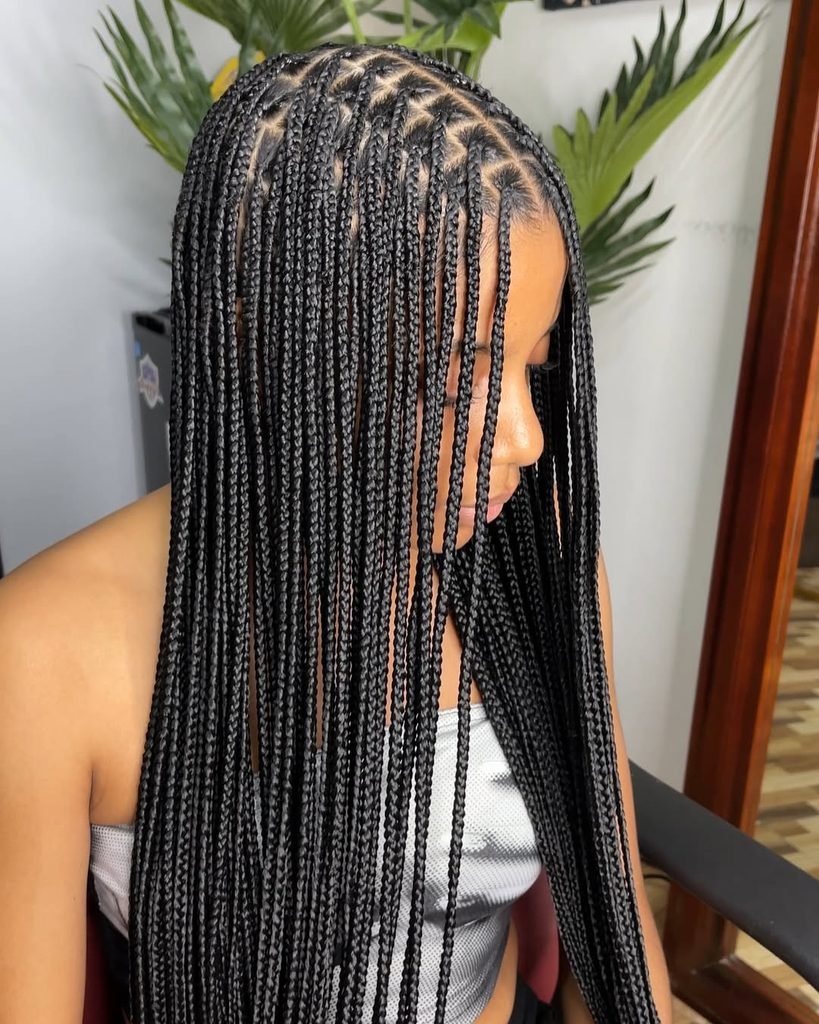 side view of a woman with long, neat black box braids