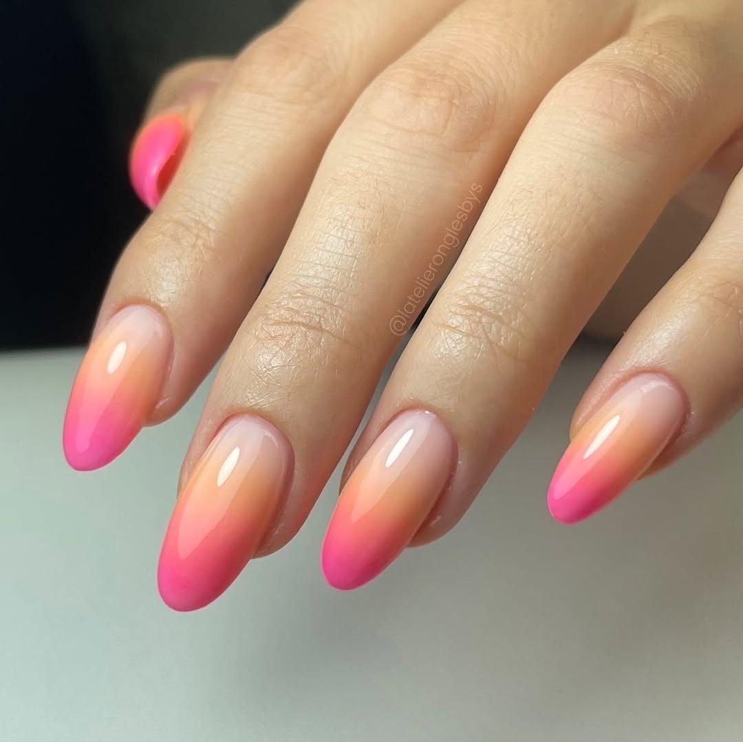 vibrant orange and pink gradient ombre manicure on long oval nails
