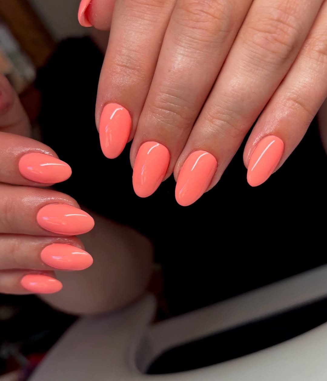 solid glossy coral pink colored summer manicure on medium almond nails