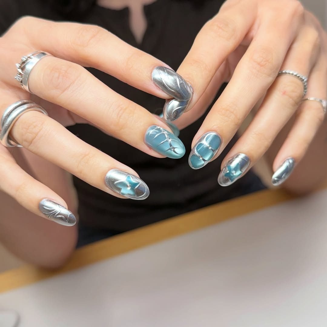 metallic silver 3d nail art with blue accents and stars on long nails