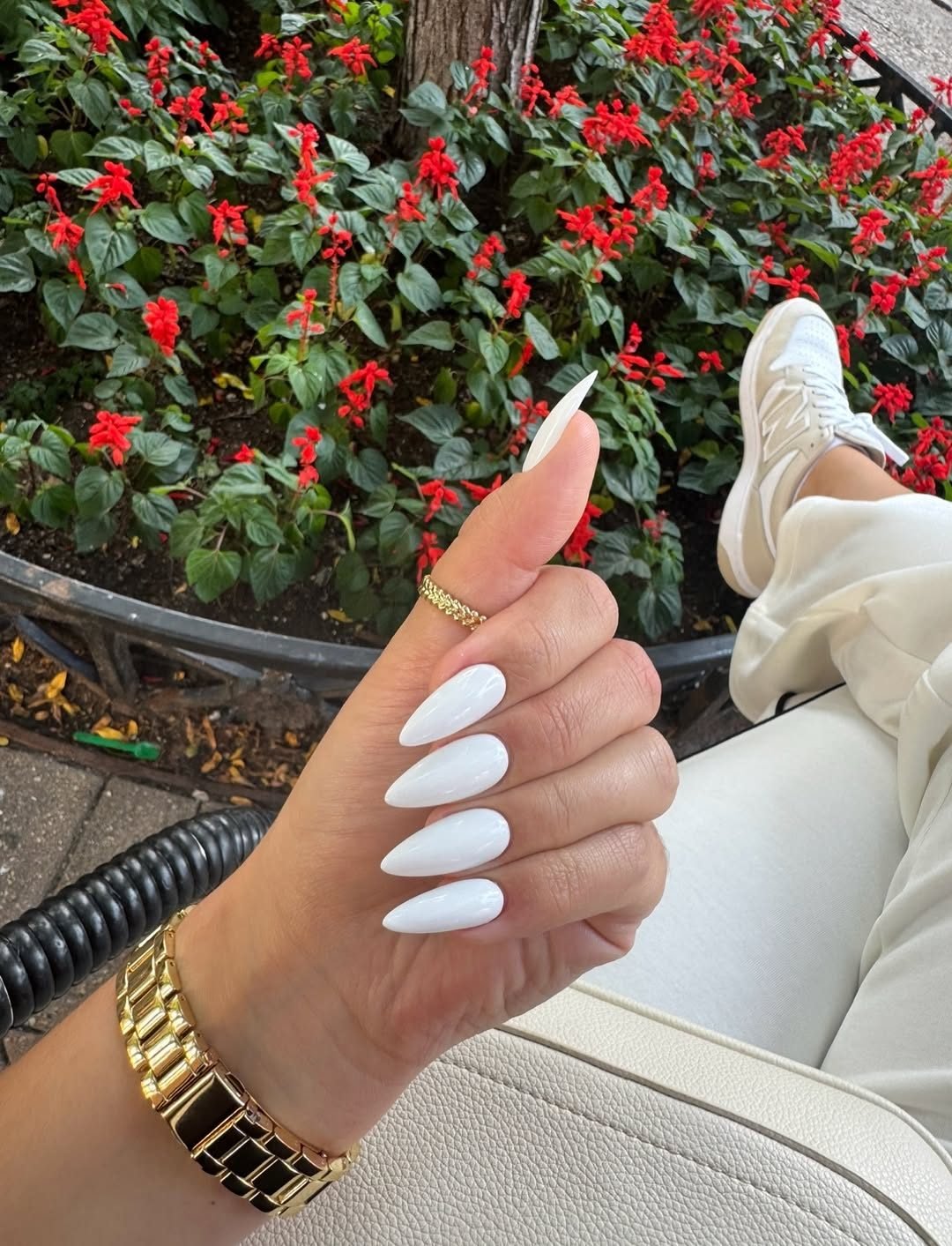 long sharp stiletto nails with a solid glossy white polish finish outdoors