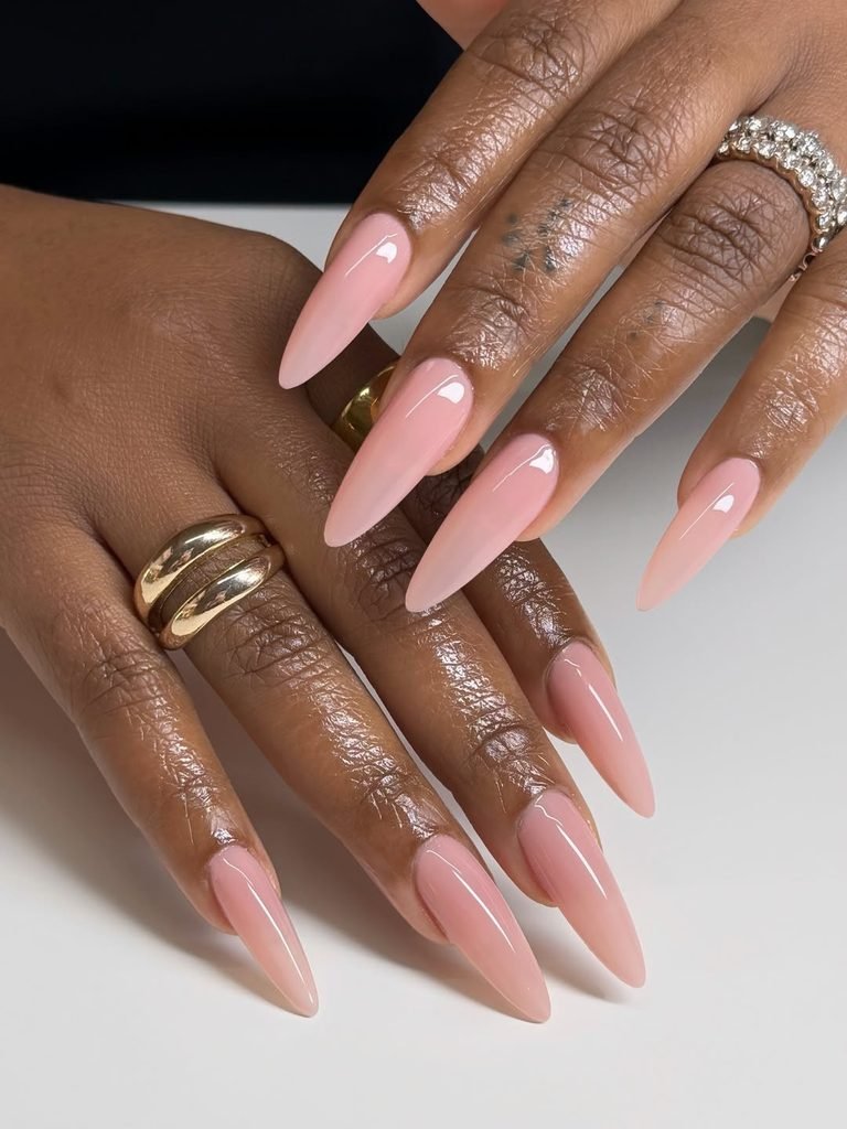 long stiletto nails with glossy nude pink polish on dark skin tones