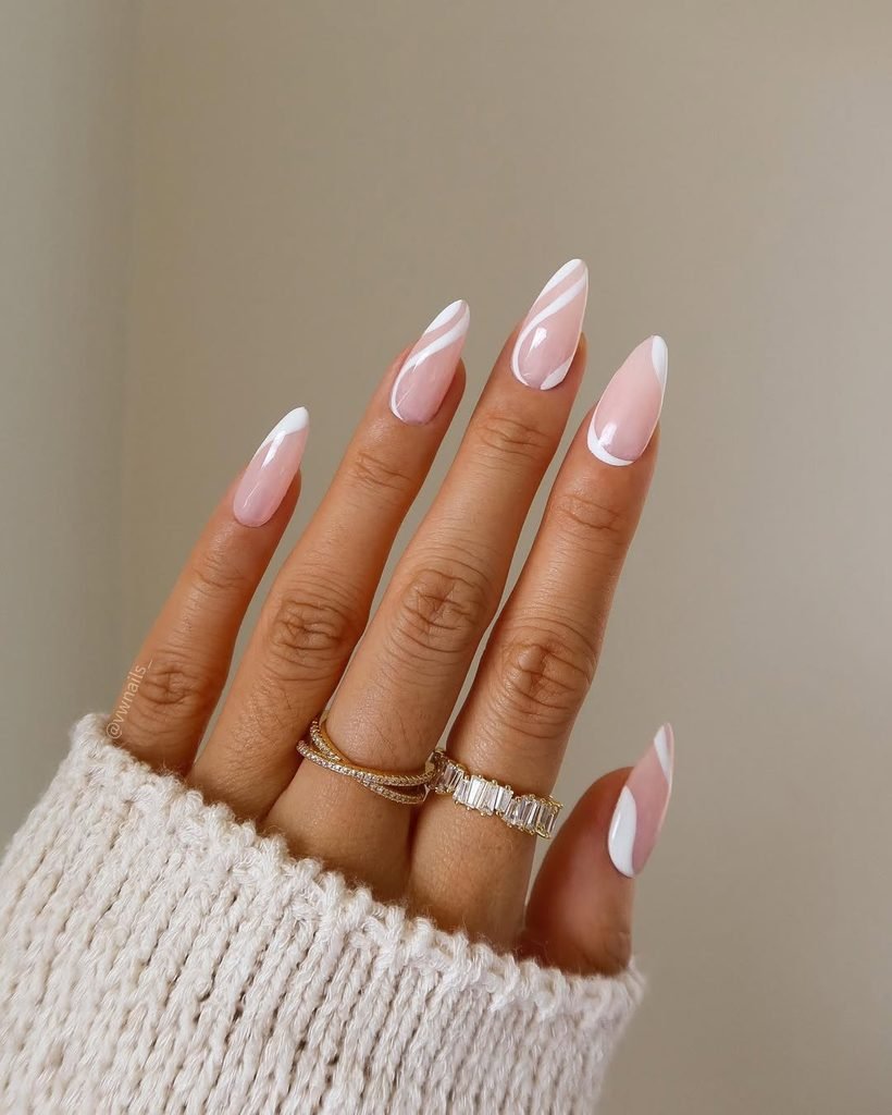 almond shaped nails featuring light pink base and white abstract swirl art
