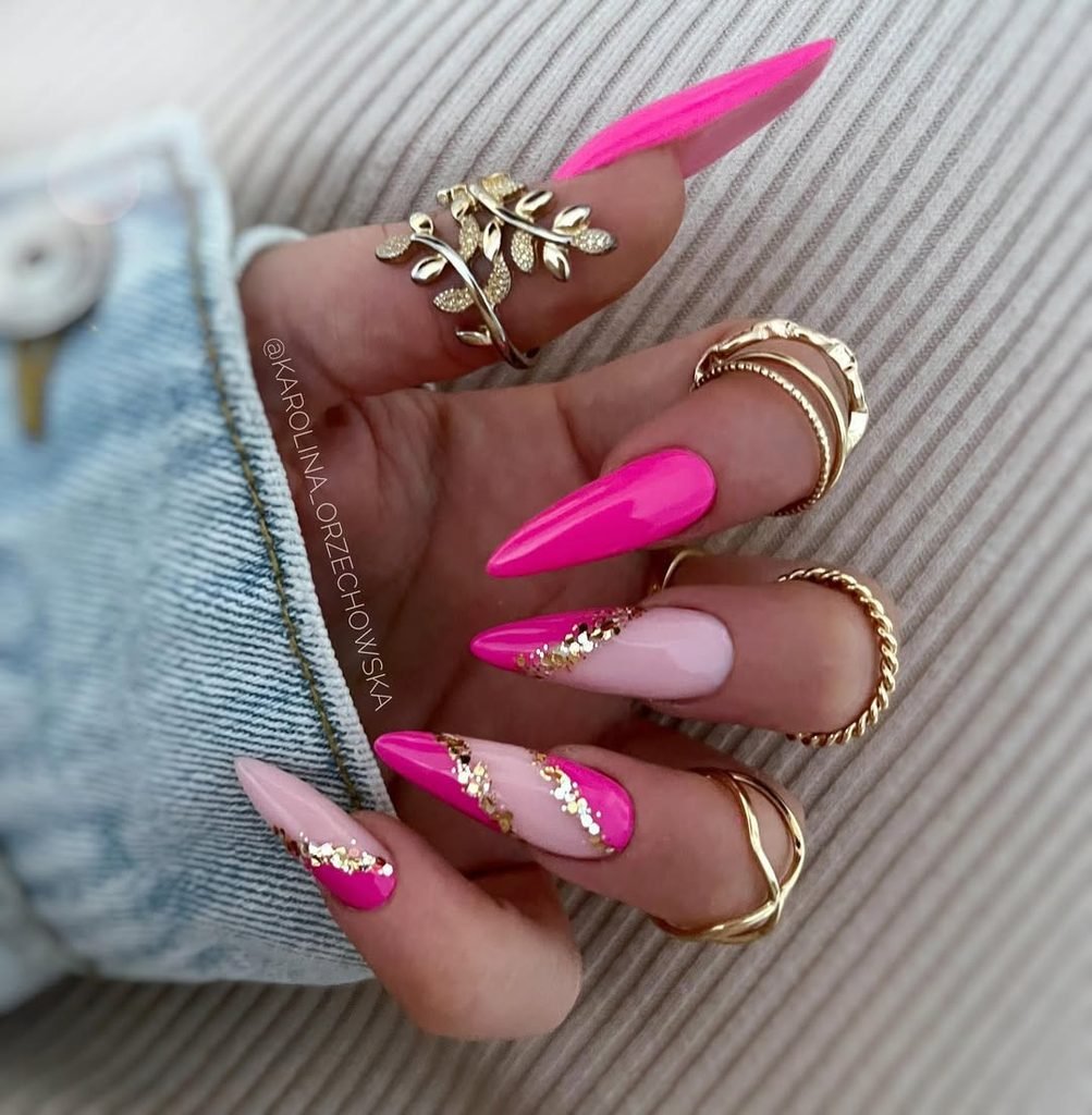 stiletto nails with hot pink, light pink, and gold glitter geometric design