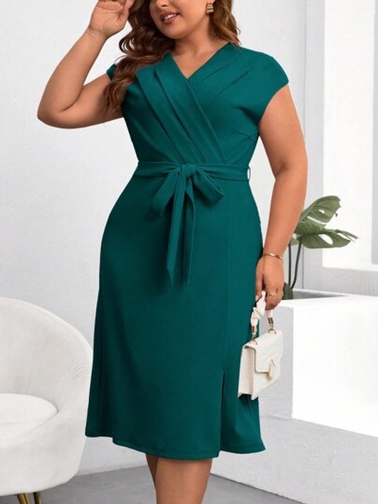 woman wearing a dark green short-sleeved wrap dress with a matching tie belt