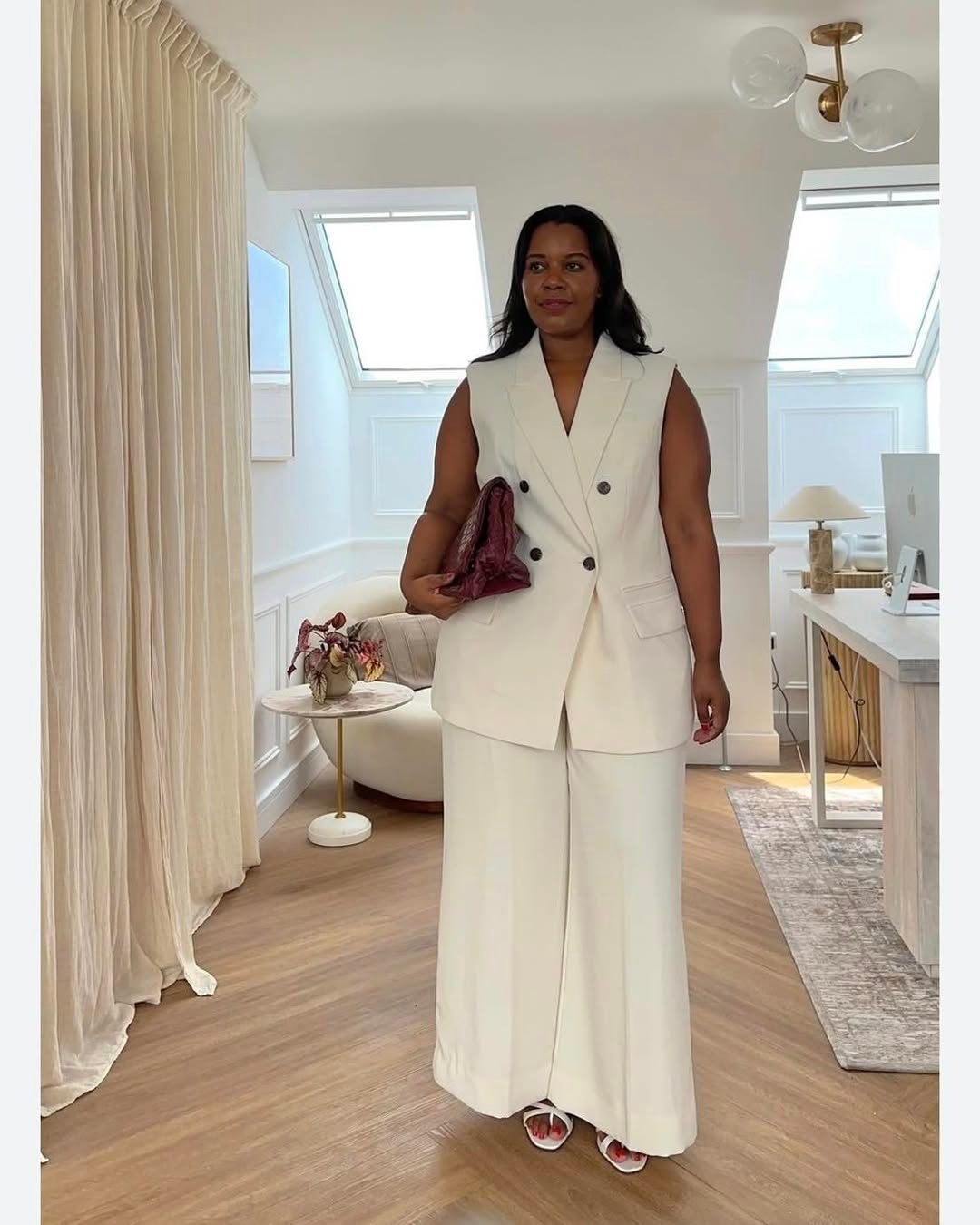 plus size woman wearing a white sleeveless double breasted blazer and wide leg trousers