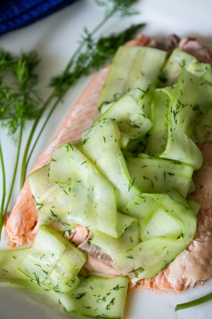 poached salmon fillet topped with thin cucumber ribbons and garnished with fresh dill sprigs