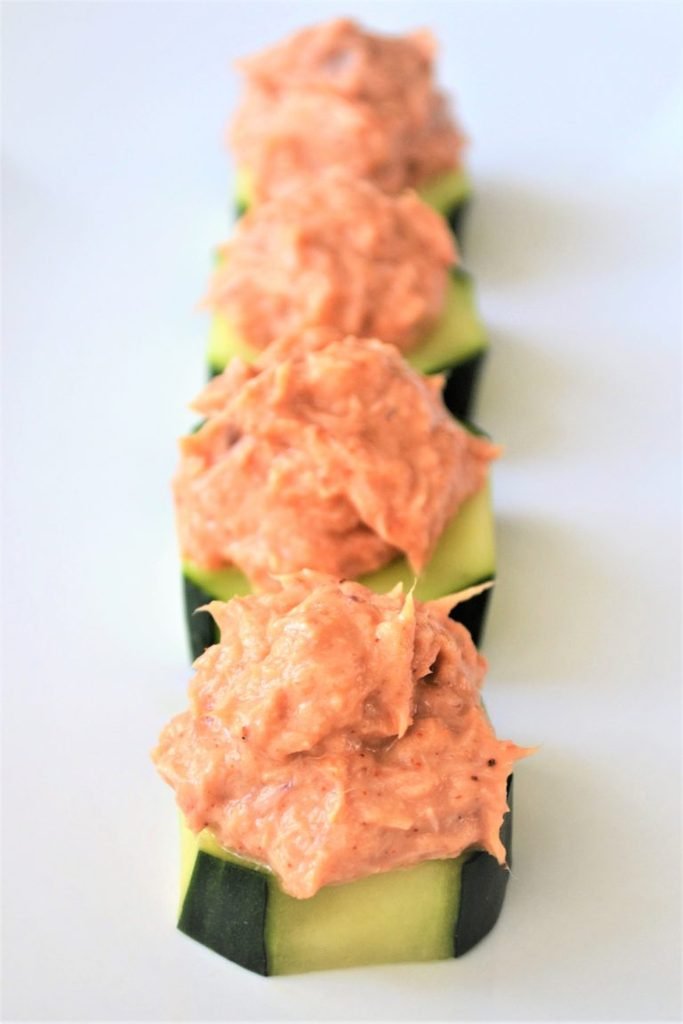 spicy tuna salad served on top of thick sliced cucumber rounds in a row