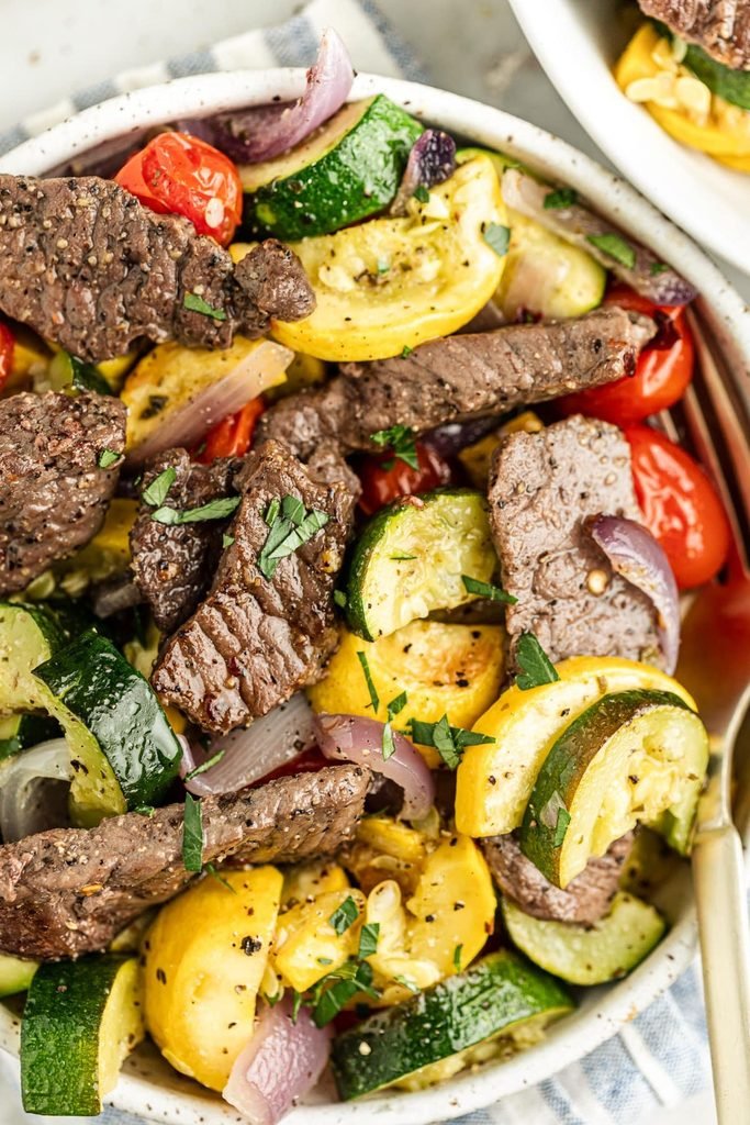 sliced steak tossed with roasted zucchini, yellow squash, onions, and cherry tomatoes