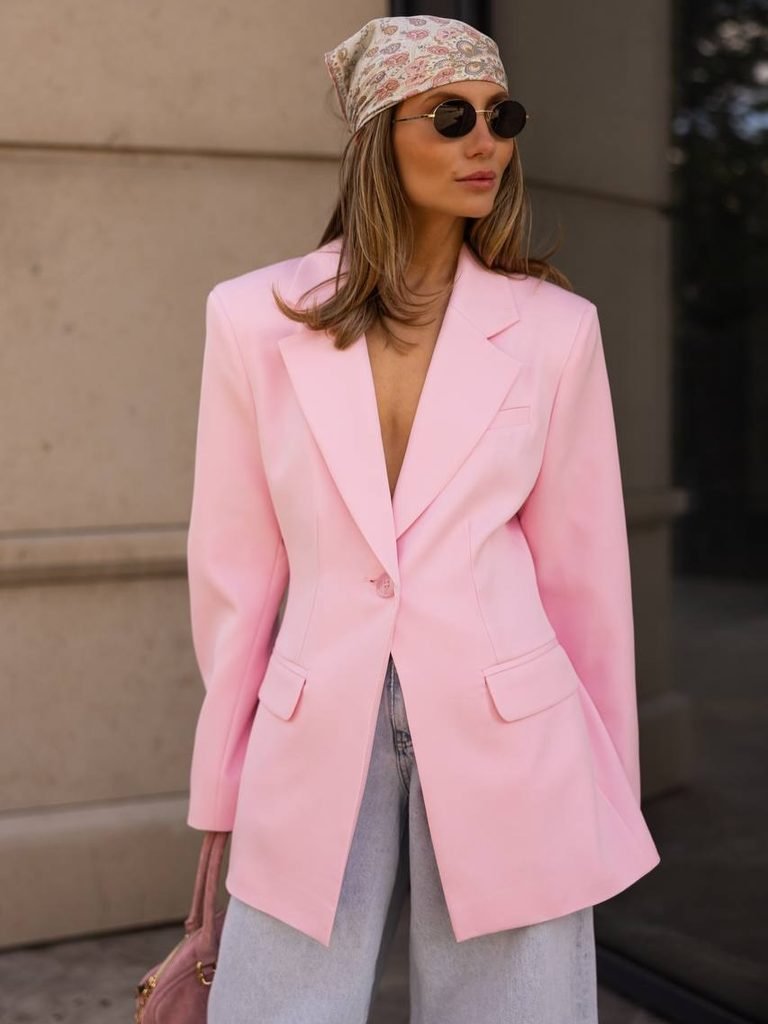 woman in pink oversized blazer sunglasses and patterned headscarf posing outdoors
