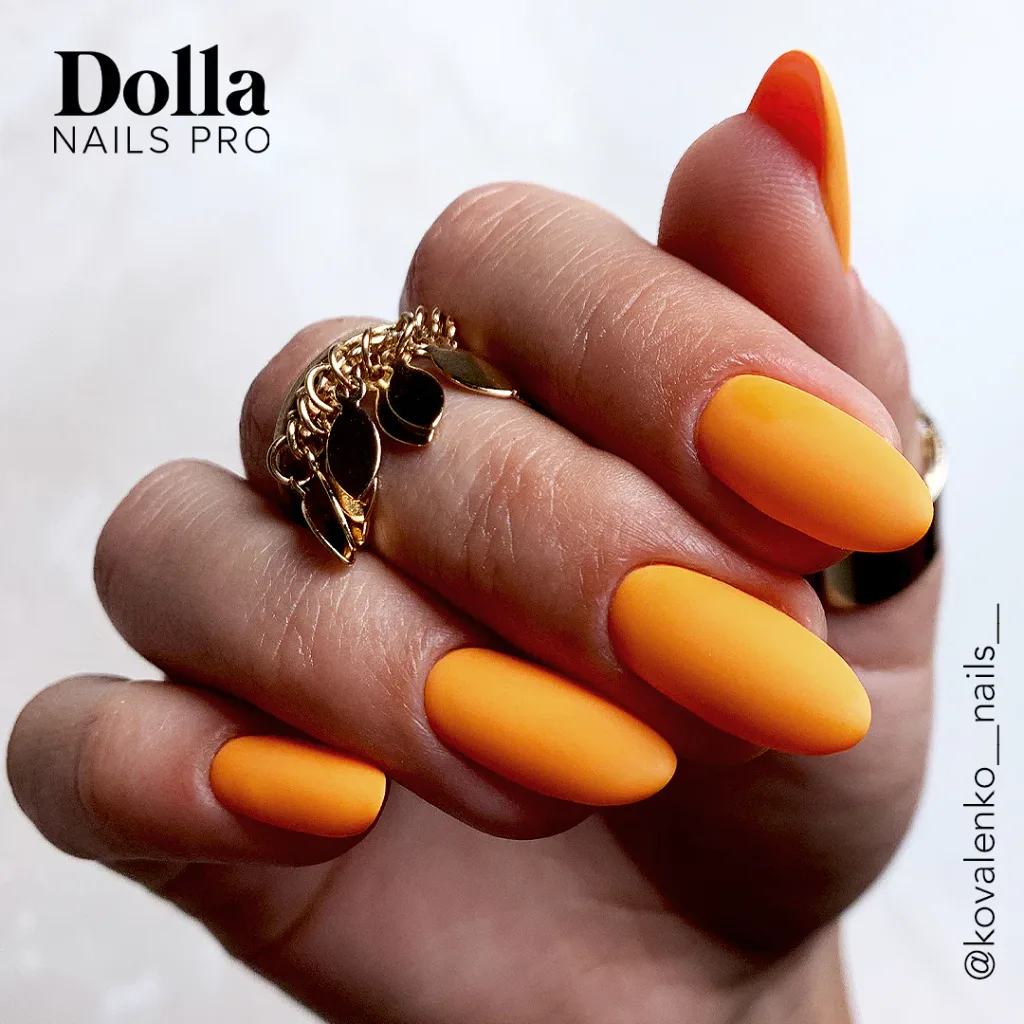vibrant matte orange manicure on oval shaped nails paired with gold rings