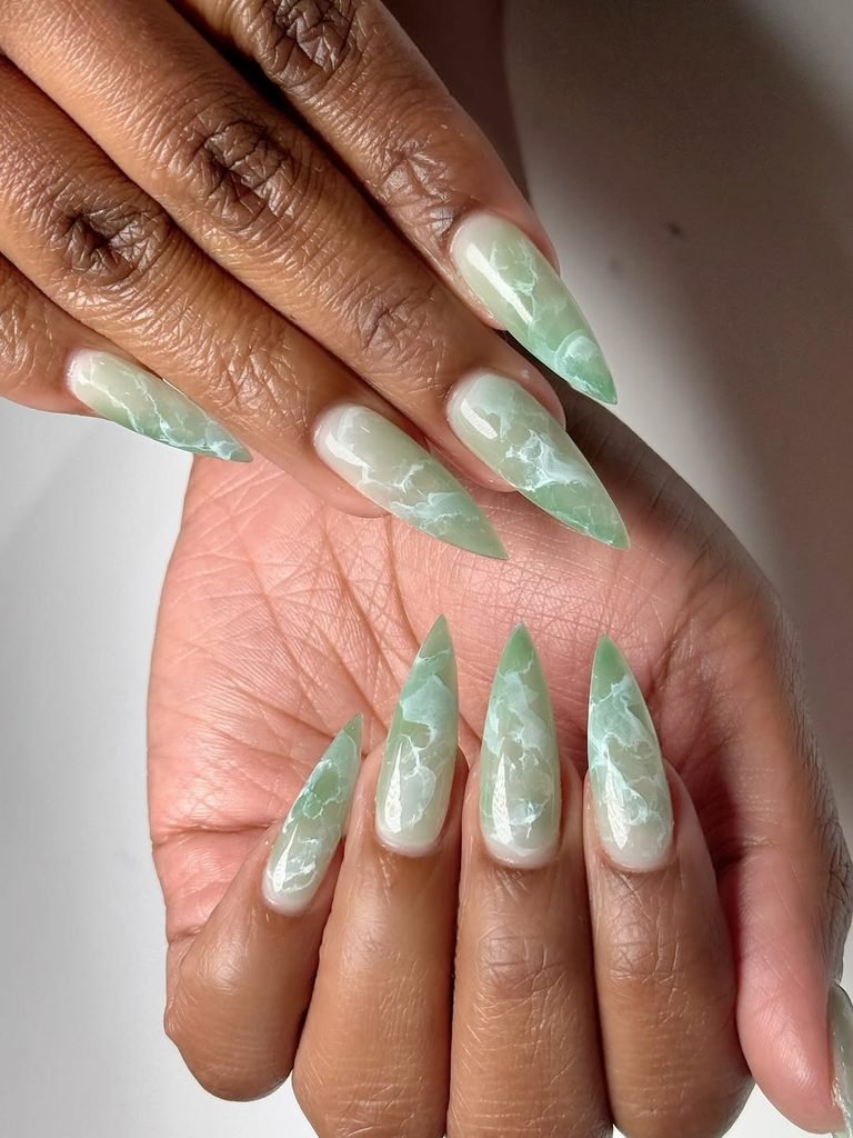 glossy jade green marble pattern nail art on sharp stiletto shaped nails