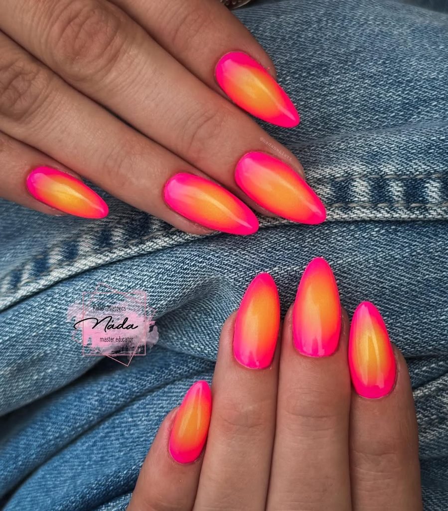 vibrant neon pink and orange ombre nail art on long almond shaped nails