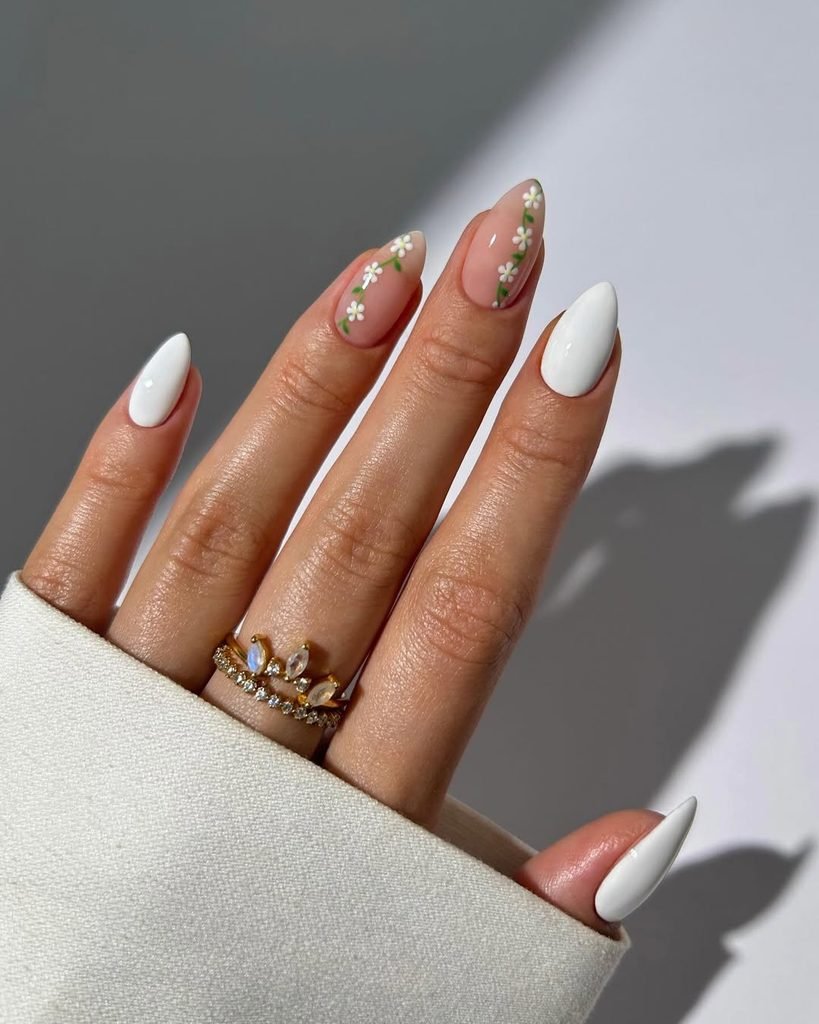 solid white stiletto manicure accented with delicate green and white daisy chain nail art