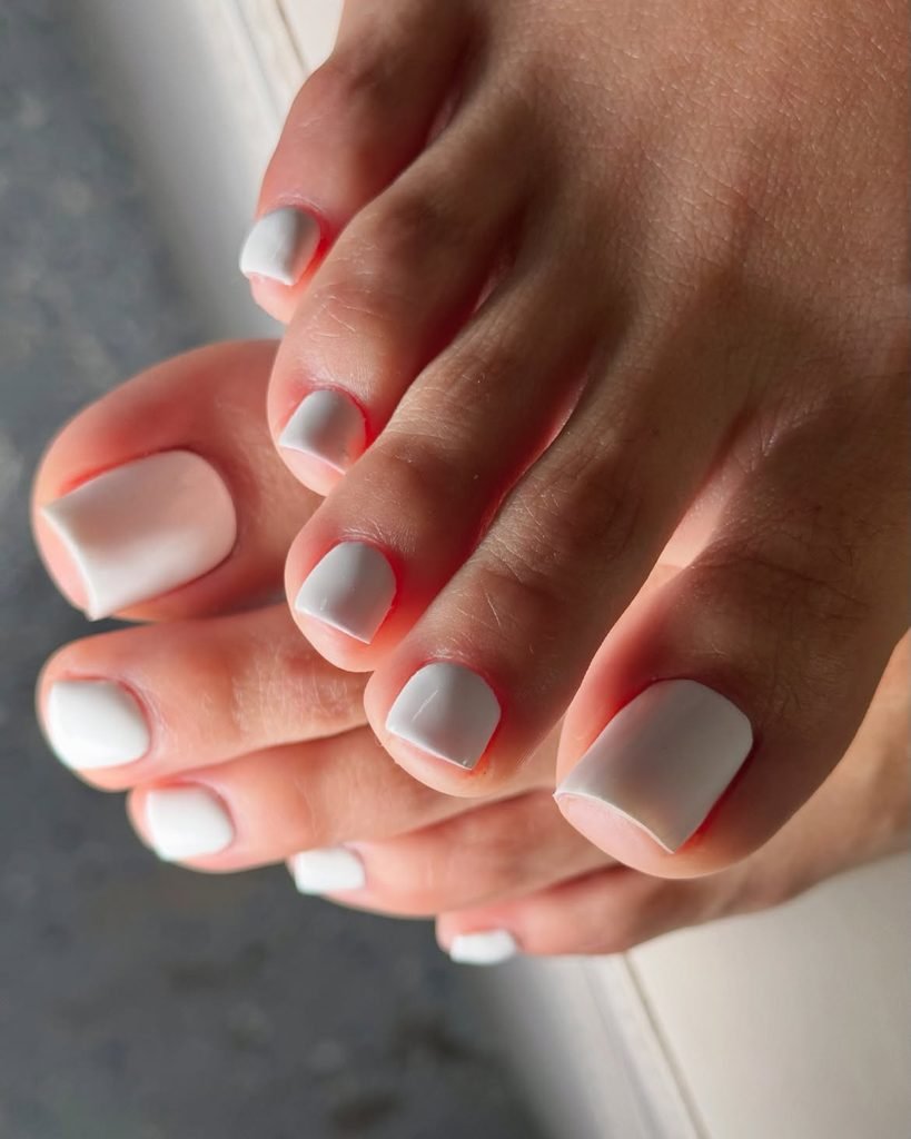 clean and crisp solid white nail polish on freshly manicured summer toe nails