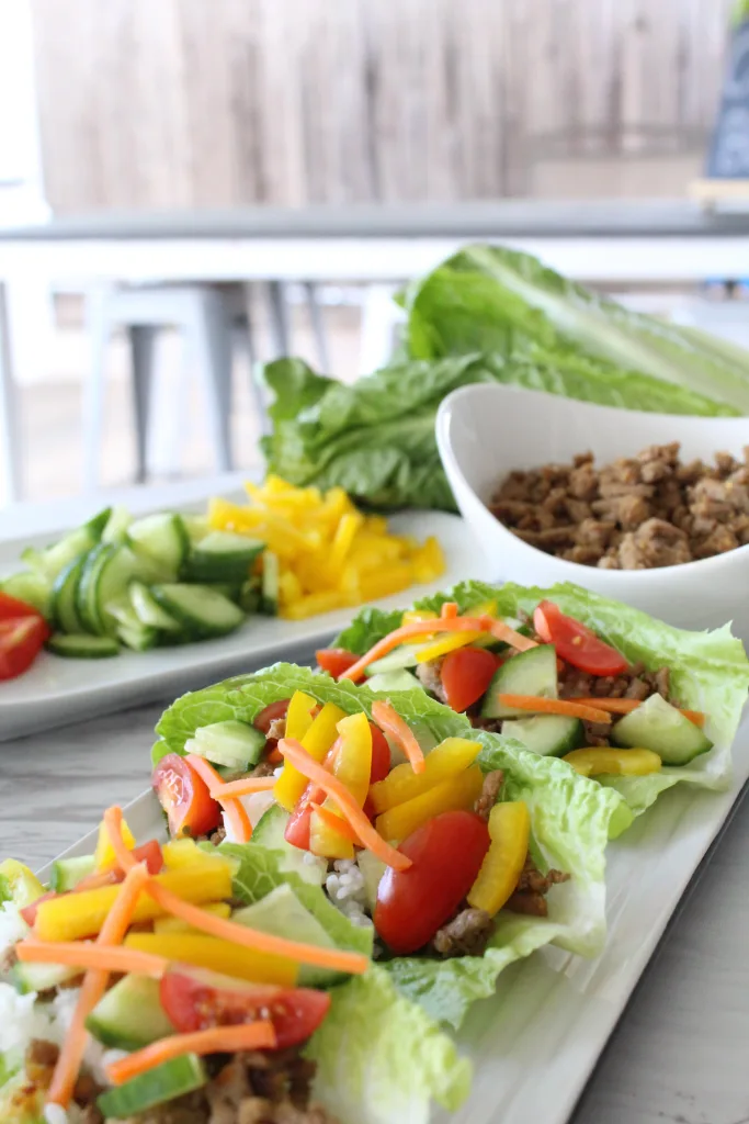 turkey lettuce cups filled with white rice, ground meat, diced bell peppers, and cucumbers