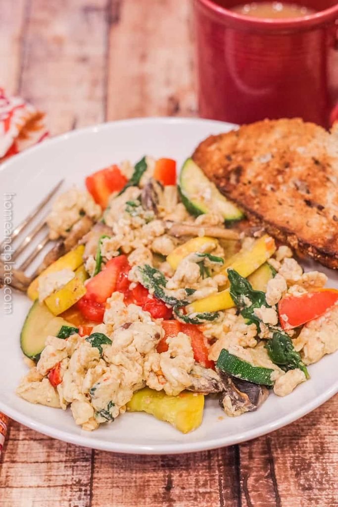 egg and vegetable scramble with zucchini, bell peppers, and a side of toast