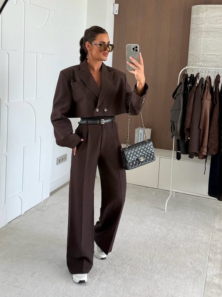 woman taking selfie wearing a cropped brown blazer and matching wide-leg pants