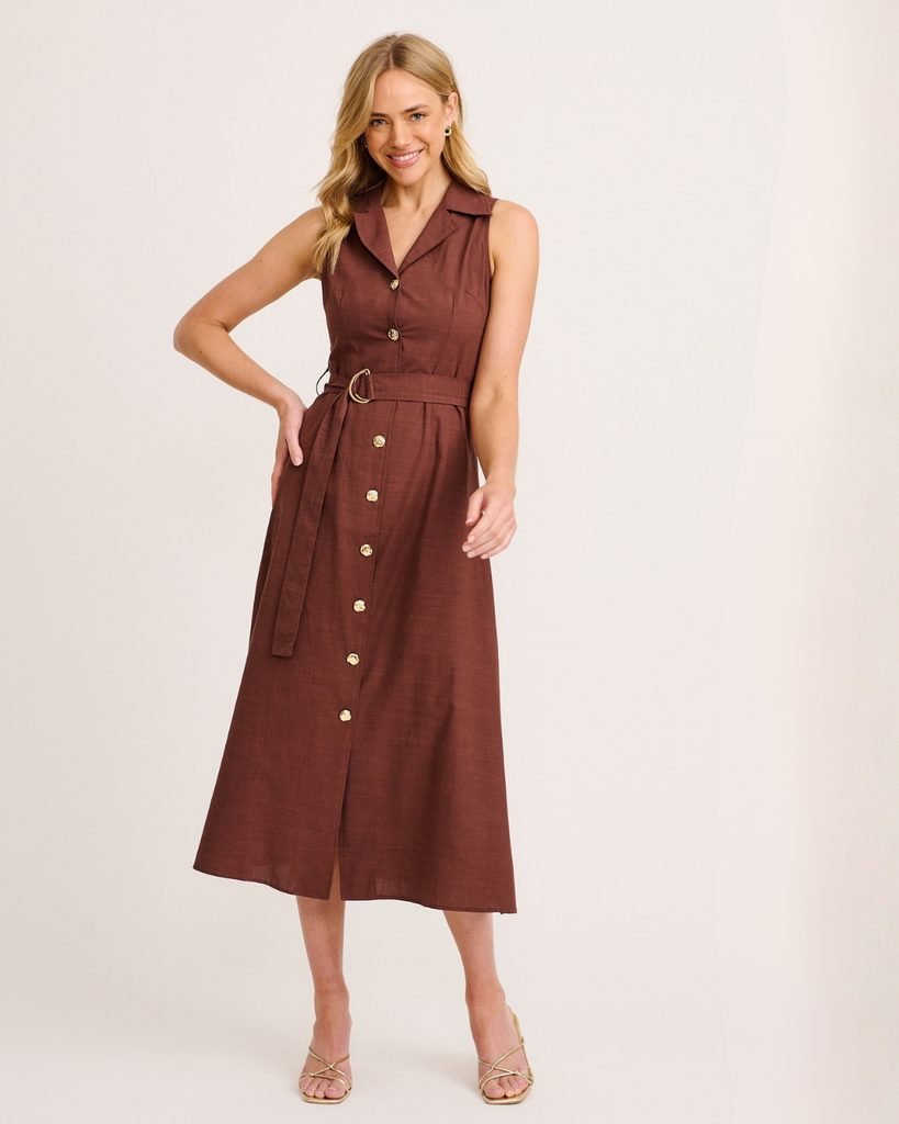 woman wearing a brown sleeveless button-down midi dress with a belt and heels