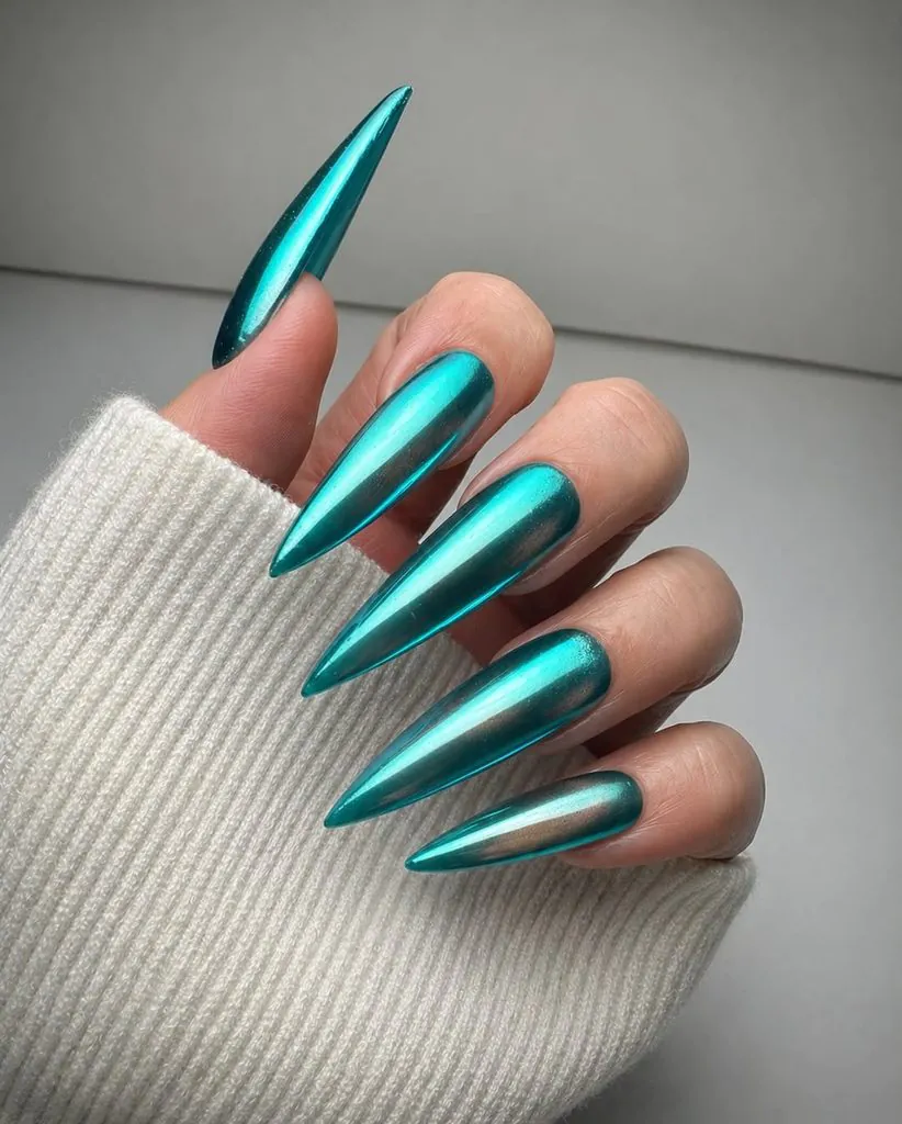 extra long stiletto nails with metallic turquoise chrome finish and white sweater sleeve