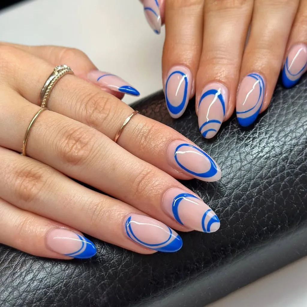 oval nude nails featuring abstract blue line swirls and concentric geometric circles
