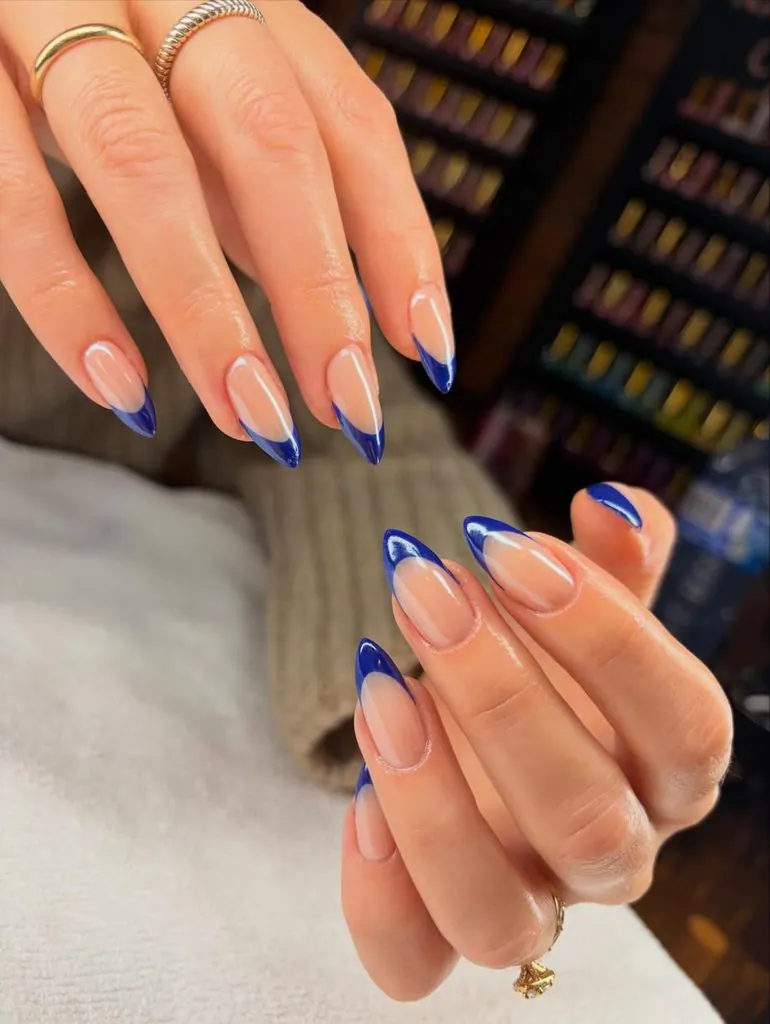 pointed almond nails with a classic deep blue French tip design