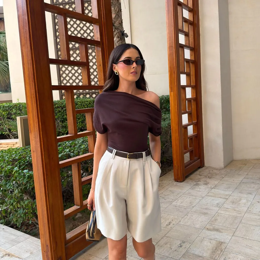 woman wearing brown off the shoulder top and beige tailored bermuda shorts