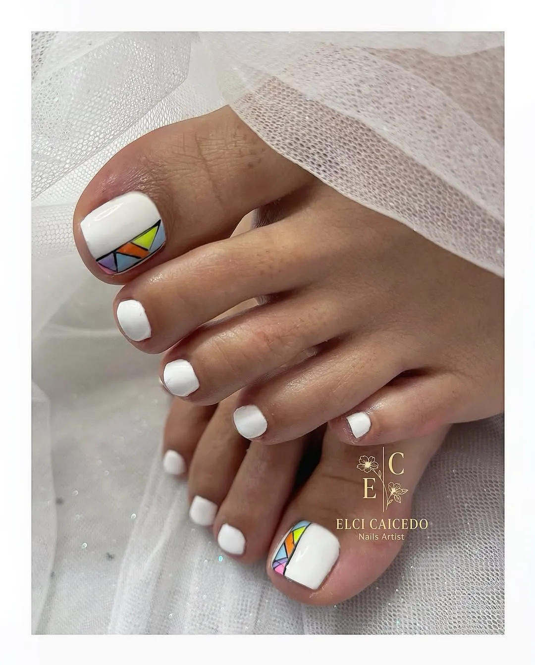 classic white pedicure featuring a colorful geometric mosaic pattern on the big toenails