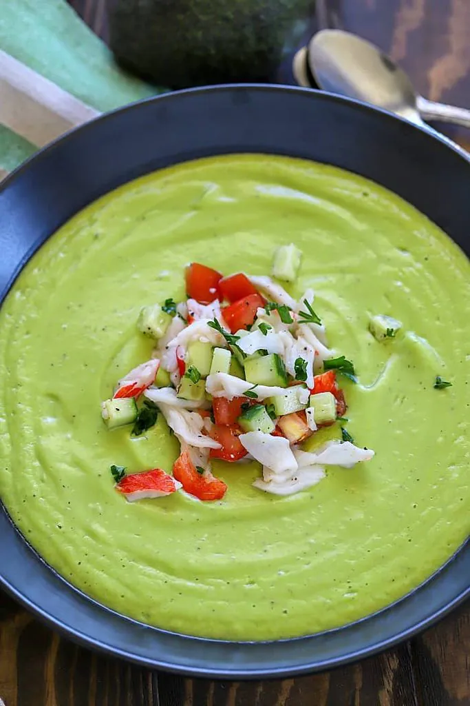 creamy green avocado soup topped with fresh crab meat, cucumber, and diced tomatoes
